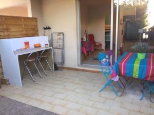 Habitación con mesa, mesa y sillas. en Studio Les Lecques 100m de la plage en Saint-Cyr-sur-Mer