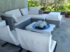 a patio with a couch and chairs and a table at Il Portico Suite de Charme in Vescina