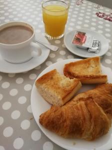 a table with two plates of bread and a cup of coffee at Apartaments Turístics Vilaró in Llorts