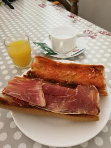 einen Teller mit einem Stück Brot mit Fleisch drauf. in der Unterkunft Apartaments Turístics Vilaró in Llorts