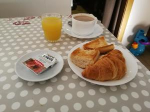 una mesa con dos platos de pan y una taza de zumo de naranja en Apartaments Turístics Vilaró, en Llorts