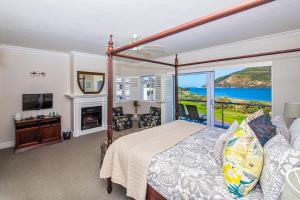 1 dormitorio con cama y ventana grande en Bollard Bay House en Knysna