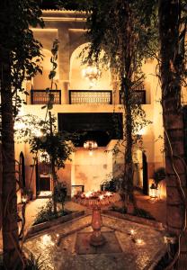 un patio con una fuente en un edificio con árboles en Riad Dar Jaguar, en Marrakech
