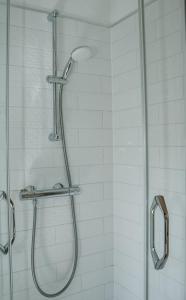 a shower with a glass shower head in a bathroom at Atpūtas Bāze Ods LOFTS in Bārta +16 photos
