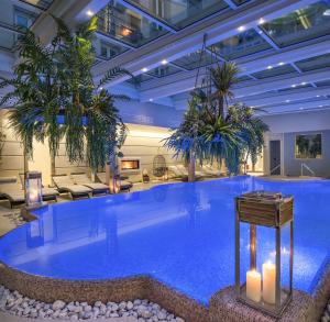una grande piscina con palme nella hall dell'hotel di Grand Hotel Salsomaggiore a Salsomaggiore Terme