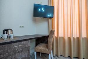 a room with a desk with a television and a chair at Golden Light Hotel in Tbilisi City