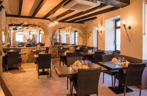 a restaurant with tables and chairs and a bar at Logis Hôtel Restaurant Cazes Arazat in Laissac