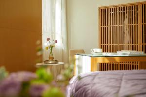a bedroom with a bed and a table with a vase of flowers at The Excelsior - Small Luxury Hotels of the World in Thessaloniki