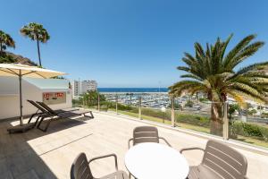 a balcony with chairs and a view of the ocean at Holiday Club Puerto Calma in Puerto Rico de Gran Canaria