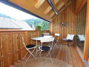 a patio with a table and chairs on a wooden deck at Apartments Maison in Kranjska Gora