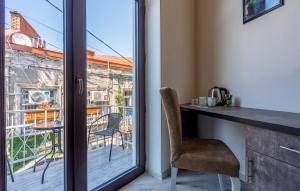 a room with a balcony with a desk and a window at Golden Light Hotel in Tbilisi City