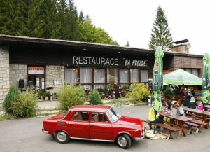 stary czerwony samochód zaparkowany przed restauracją w obiekcie Penzion a restaurace Na Hvězdě w mieście Malá Morávka