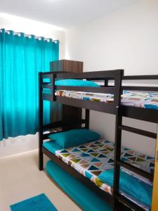 two bunk beds in a room with blue curtains at JAS Marina Spatial in Dumaguete