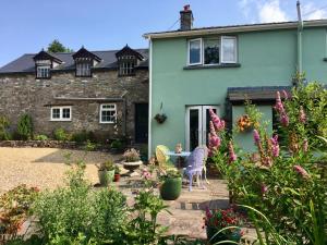 a garden in front of a house with flowers at Brecon Boutique Breaks River Run in Sennybridge