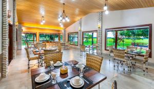 um restaurante com mesas, cadeiras e janelas em Pousada Piuval em Poconé
