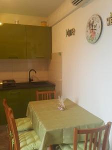 een keuken met een tafel en een klok aan de muur bij Apartments Davor in Postira
