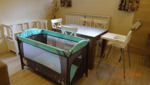 a room with a table and a crib with a table and chairs at Ski & Bike Residence in Poiana Brasov