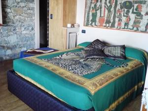 a bed in a room with a green comforter and pillows at Le case di Recco by Holiday World in Recco