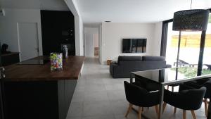 een keuken en een woonkamer met een tafel en stoelen bij Villa Gavrinis in Ploemel