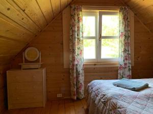 a bedroom with a bed and a window at Święty Spokój Łąka i Woda in Pozezdrze