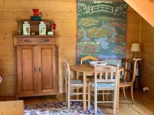 a dining room with a table and chairs and a wall at Święty Spokój Łąka i Woda in Pozezdrze
