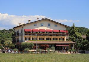 un gran edificio con toldos rojos. en Hotel da Roberto, en Lazise