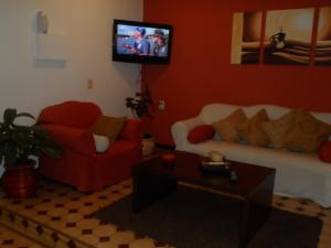 a living room with two couches and a tv at Hotel Minas in Minas