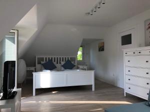 ein Schlafzimmer mit einem weißen Bett mit blauen Kissen in der Unterkunft Budapester Hof Gästehaus in Hamburg