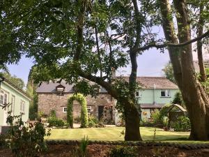 a house with a yard with trees in the foreground at Brecon Boutique Breaks Wild Land in Sennybridge
