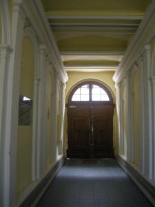 un couloir vide avec une porte en bois et une fenêtre dans l'établissement Appartements CHE, à Vienne