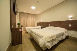 a hotel room with two beds in a room at Hotel Leiria in Matão +54 photos