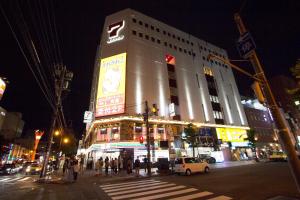 a large building on a busy city street at night at Hokkaido 7 - inn in Asahikawa