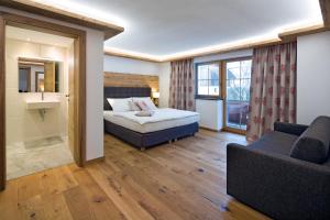 pokój hotelowy z łóżkiem i kanapą w obiekcie Blattlhof w mieście Sankt Johann in Tirol