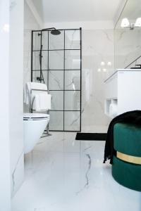 a bathroom with a toilet and a sink and a tub at Apartament MARCELIN GOLD Wes Quality Suite in Poznań +19 photos