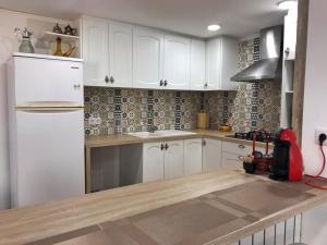 una cucina con armadietti bianchi e frigorifero bianco di Cal Pere de L'Onclet a Montblanc