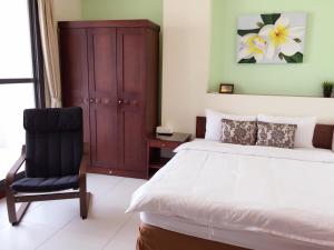 um quarto com uma cama e uma cadeira em Corner No.56 Guest House em Hengchun Old Town