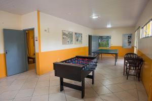 um quarto com uma mesa de pingue-pongue e uma mesa em Vila Olaria Hotel em Penha