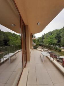 a balcony with two white chairs and a view of trees at Vesta Riviera - Free Parking in Golden Sands