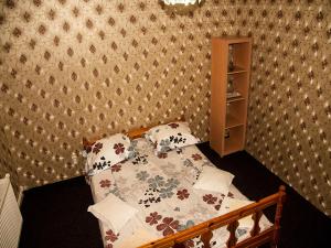 a small bedroom with a bed with a comforter and pillows at Pensiunea Contour in Iaşi