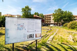 una señal en un campo con un edificio en el fondo en A cà du Piero, en Albisola Superiore