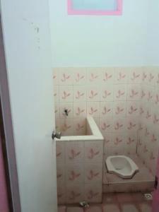 La salle de bains est pourvue de toilettes avec des papillons roses sur le mur. dans l'établissement Almira Homestay near Airport, à Jambi