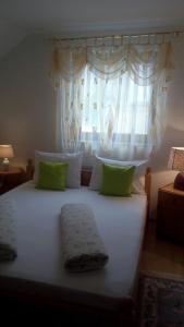 a bedroom with a large white bed with a window at Apartman AS in Livno
