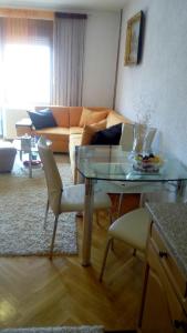 un soggiorno con tavolo in vetro e divano di Apartman AS a Livno