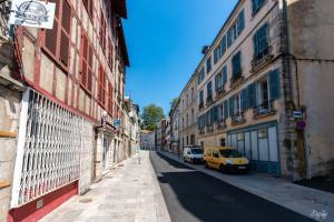 バイヨンヌにあるmagnifique appartement hypercentre toutes commoditésの路上に黄色い車が停まった建物のある通り