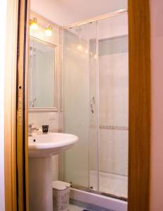 ein Badezimmer mit einem weißen Waschbecken und einer Dusche in der Unterkunft Butterfly casa vacanze in Sutri