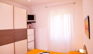 Schlafzimmer mit einem Bett und einem Fenster mit einem TV in der Unterkunft Butterfly casa vacanze in Sutri