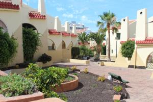 un cortile con panchina e palme presso il resort di Holiday in Mareverde ad Adeje