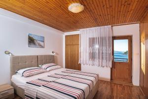 1 dormitorio con cama y ventana con vistas al océano en Apartments Stokic, en Donja Klada