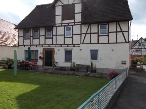 a white and black house with a yard at Ferienhaus Klinder in Bad Arolsen