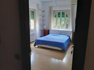 a bedroom with a blue bed and two windows at Arches B&B in Rome